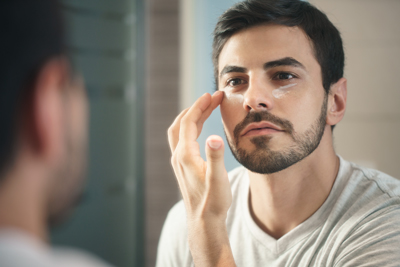 Photo d’un homme appliquant un produit de soin de la peau avec des silicones